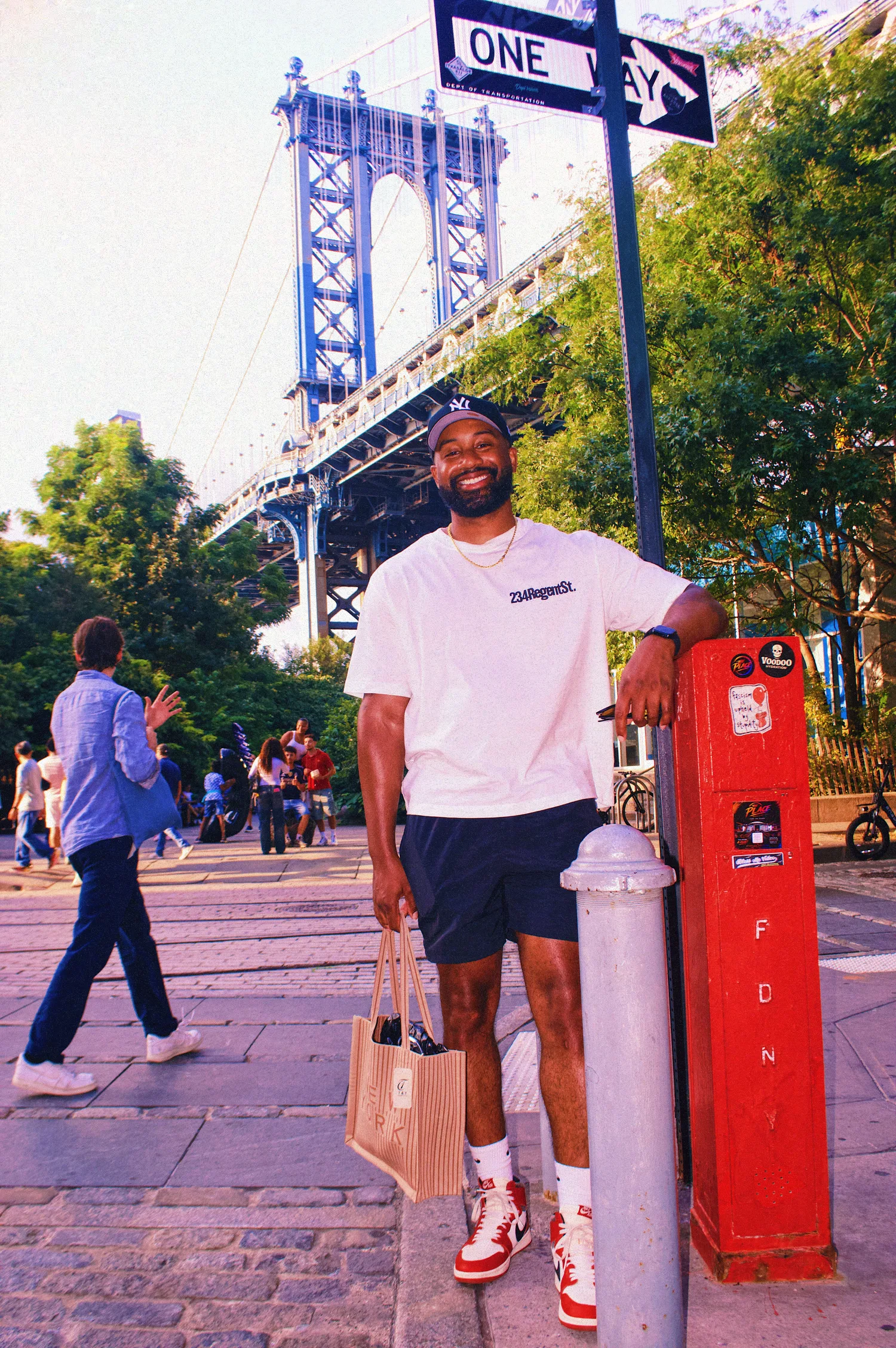 Keon NaVarr smiling on a cobblestone street beneath a bridge