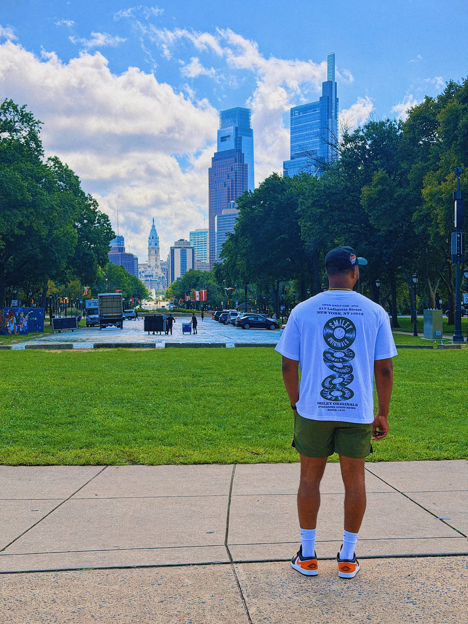 Keon NaVarr looking toward a city skyline across a green lawn